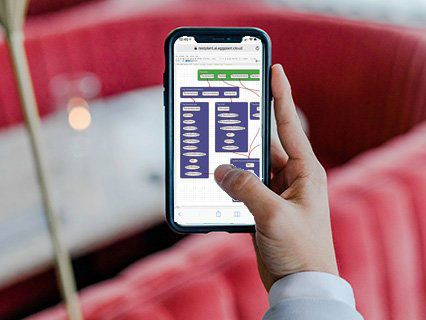 Eggplant displayed on the screen of a mobile phone being held in a person's right hand.  decoding=