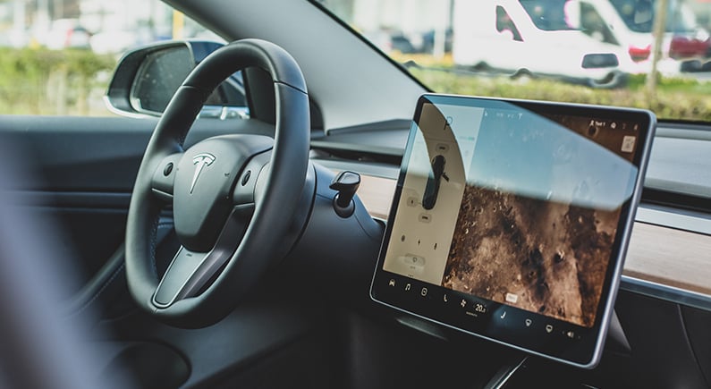 Tablet mounted next to a Tesla steering wheel.